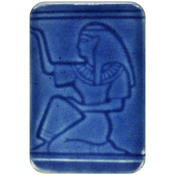 White clay tile featuring an imprint of a kneeling pharoah glazed with Spectrum 1464 Moroccan Blue Semi-Transparent Glazepooled into the indentations