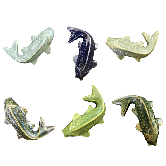 Set of six ceramic fish figurines in various colors on a white background